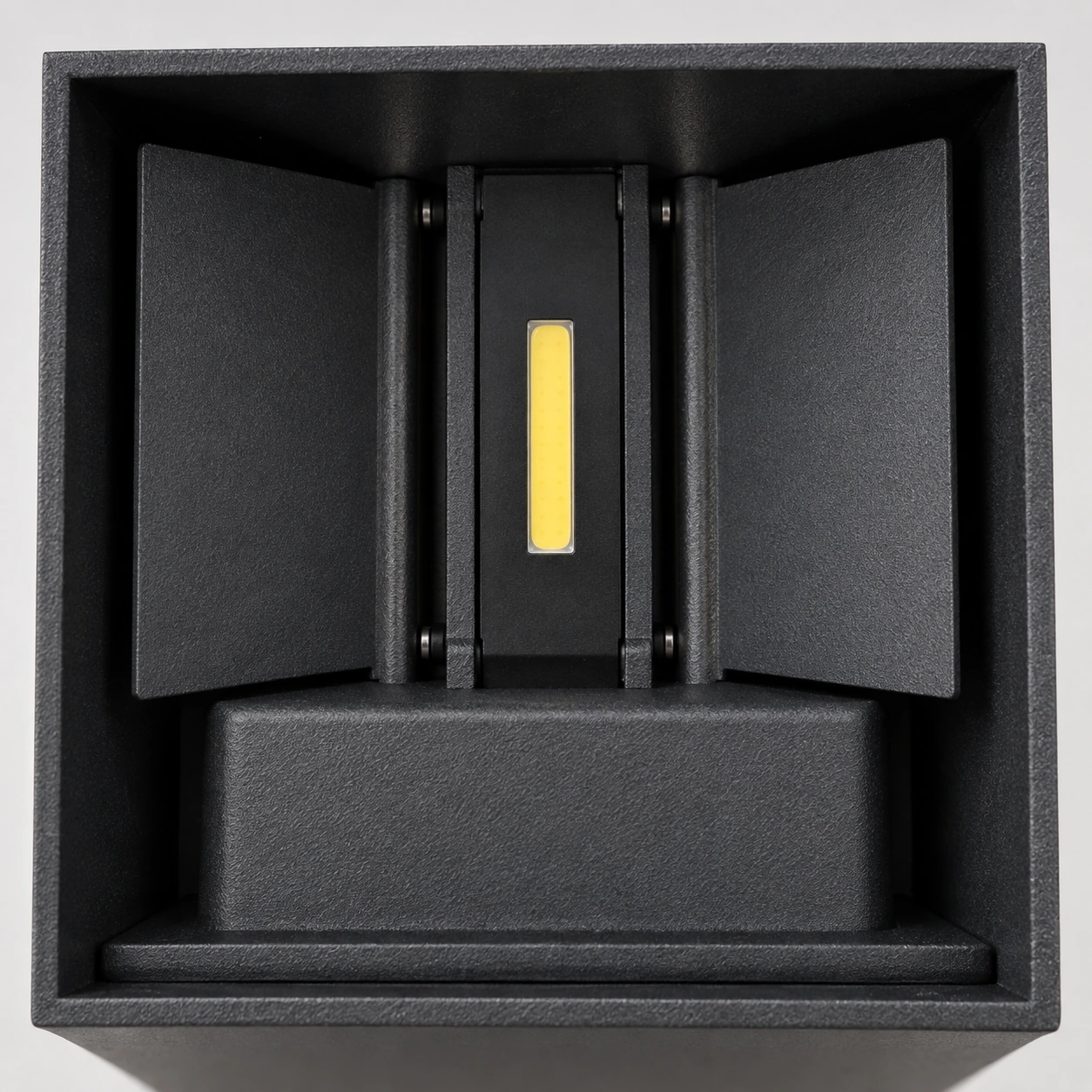 L'intérieur du boîtier noir : platine centrale, bande LED jaune et deux volets orientables