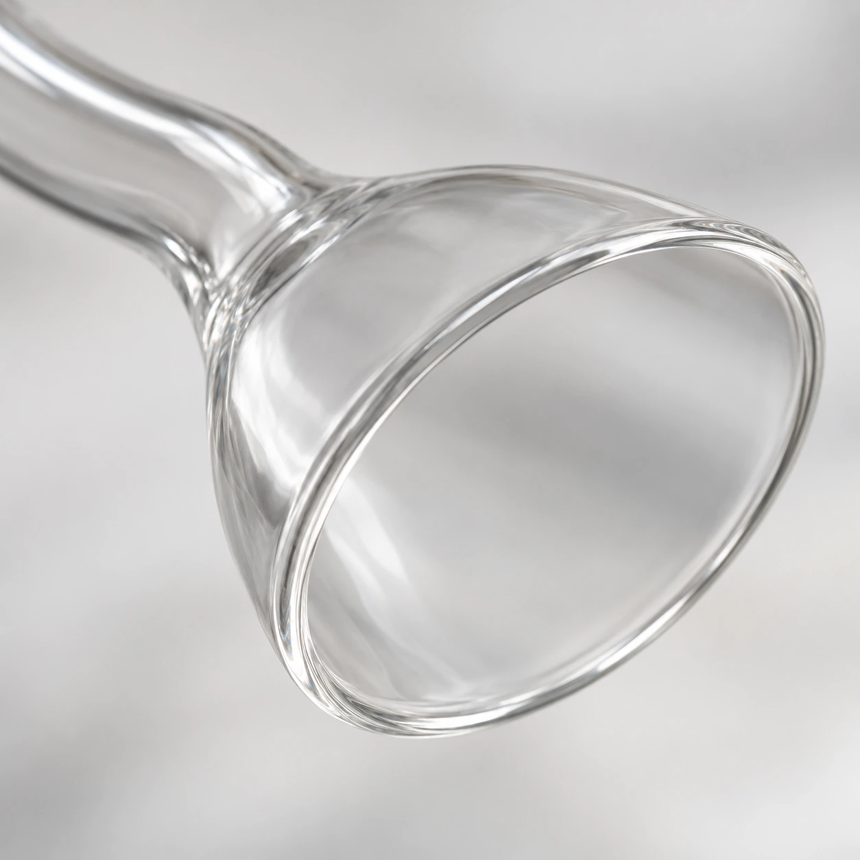 Gros plan sur l’embouchure évasée : lèvre polie et ouverture ovale du verre mince