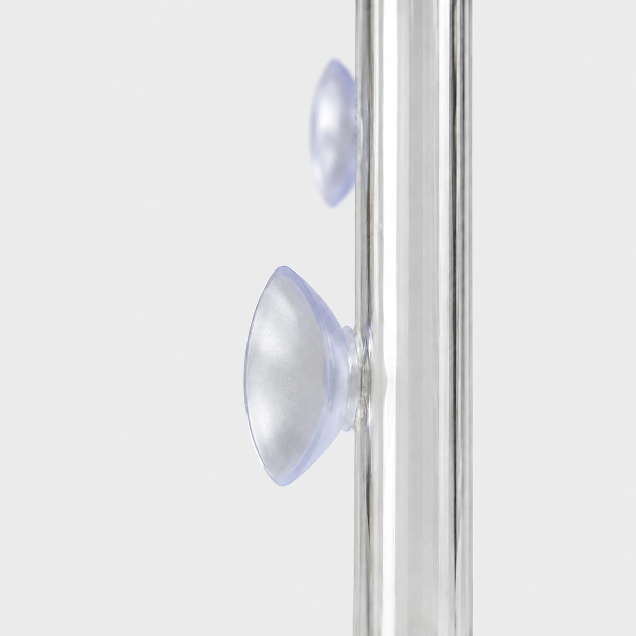 Le détail d’une ventouse en silicone translucide posée sur le tube en verre, une seconde plus loin sur le même tube