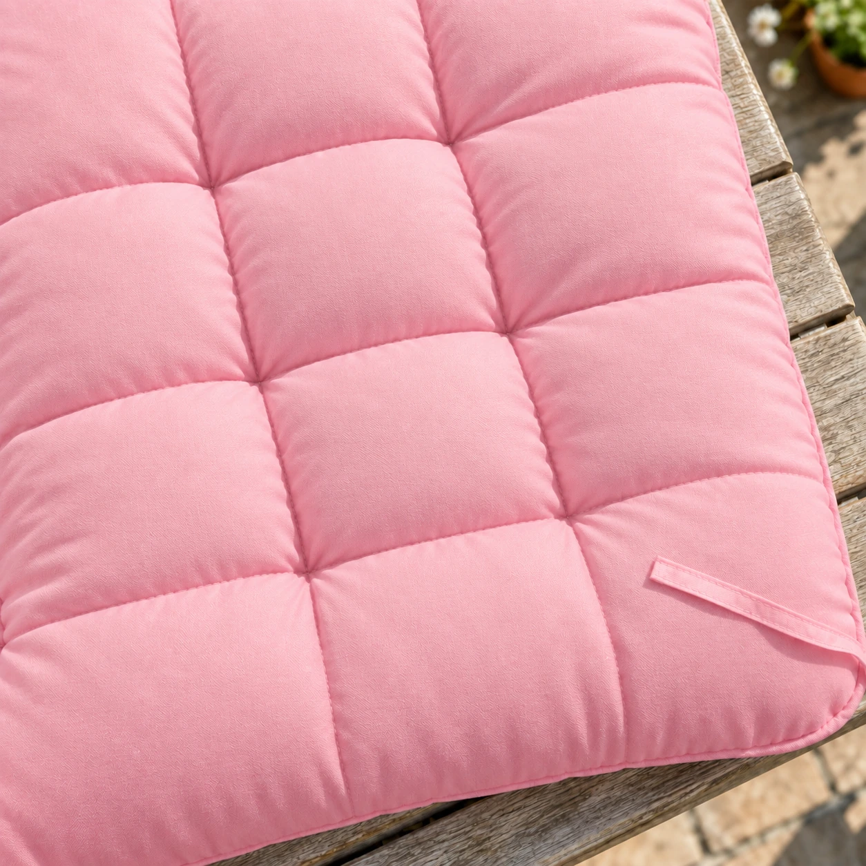 Gros plan du capitonnage du coussin rose, cellules gonflées séparées par des coutures droites