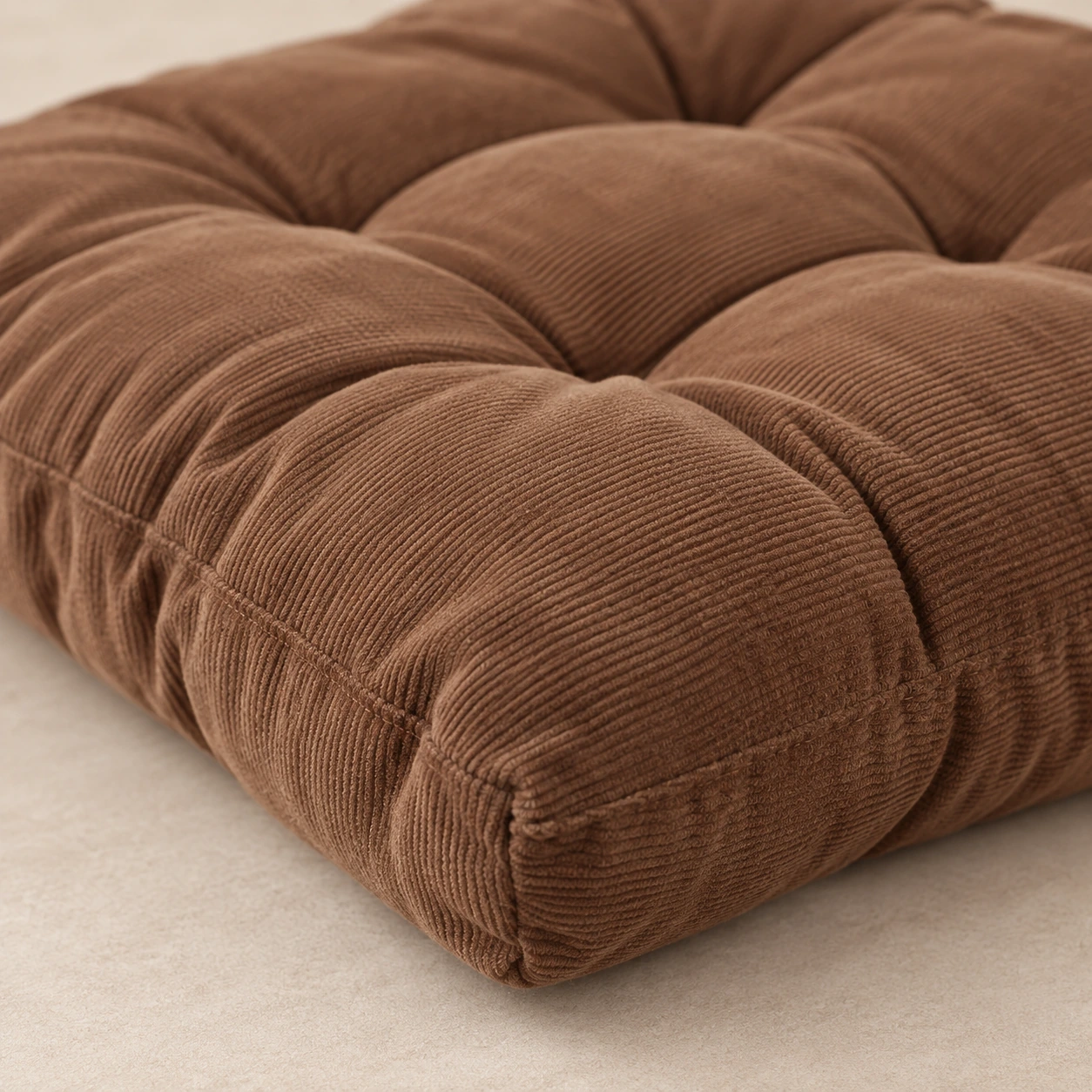 Vue de côté du coussin d'assise marron montrant son épaisseur et la couture de bord