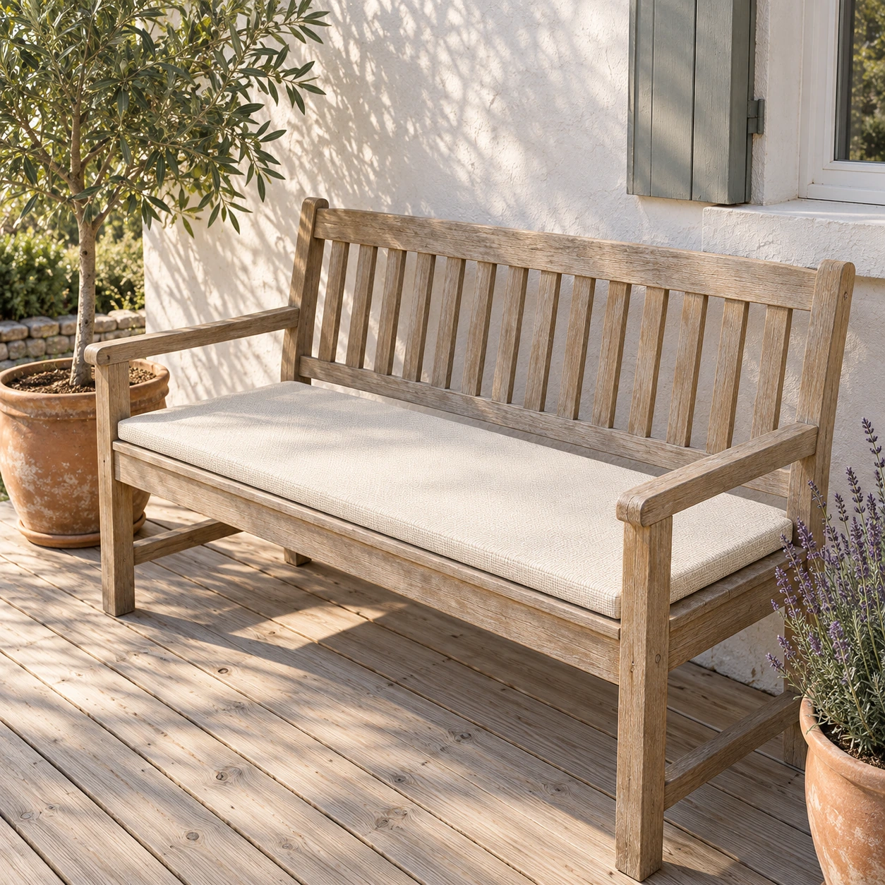 Banc en bois clair d'une terrasse française garni de la galette blanc cassé sur toute sa longueur