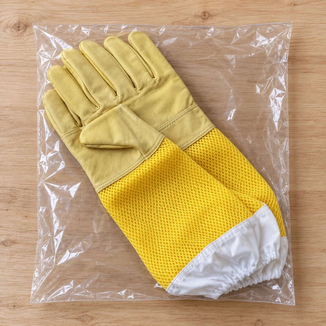 La paire de gants pliée à plat dans son sachet transparent scellé, contenu du colis
