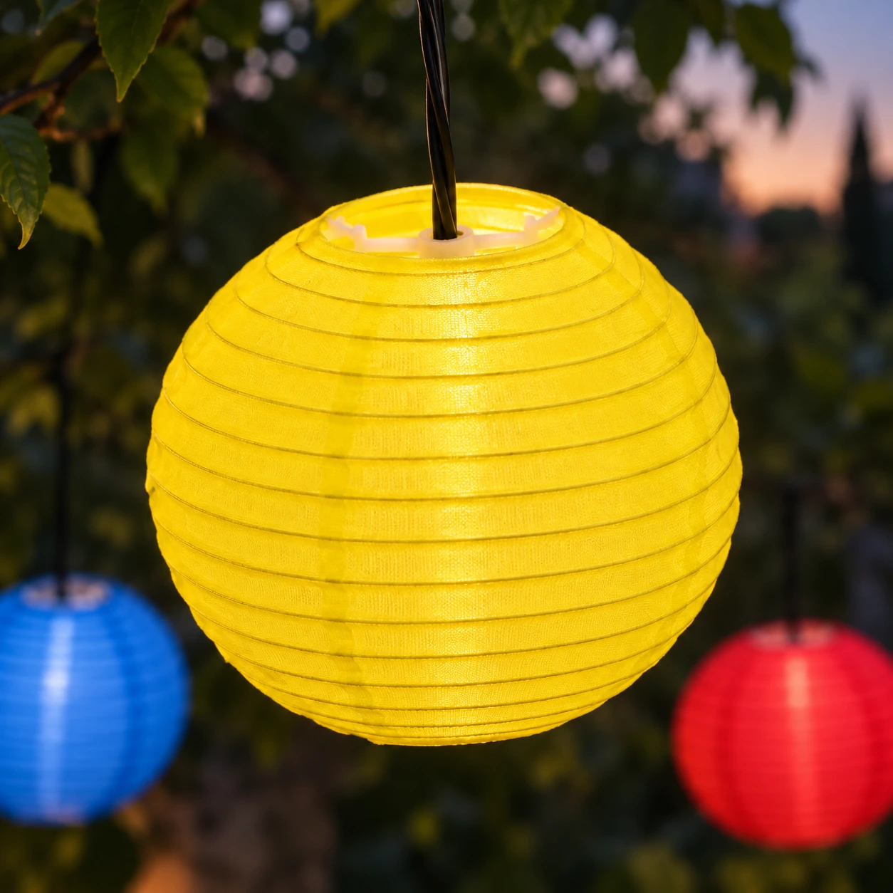 Lanterne de tissu jaune allumée, son clip blanc visible dans l'ouverture du haut