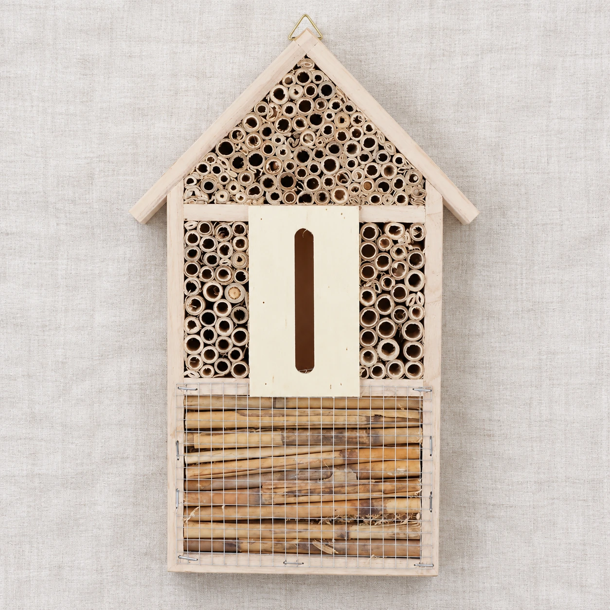 Contenu du colis vu de dessus : une maisonnette à insectes posée à plat sur un linge clair