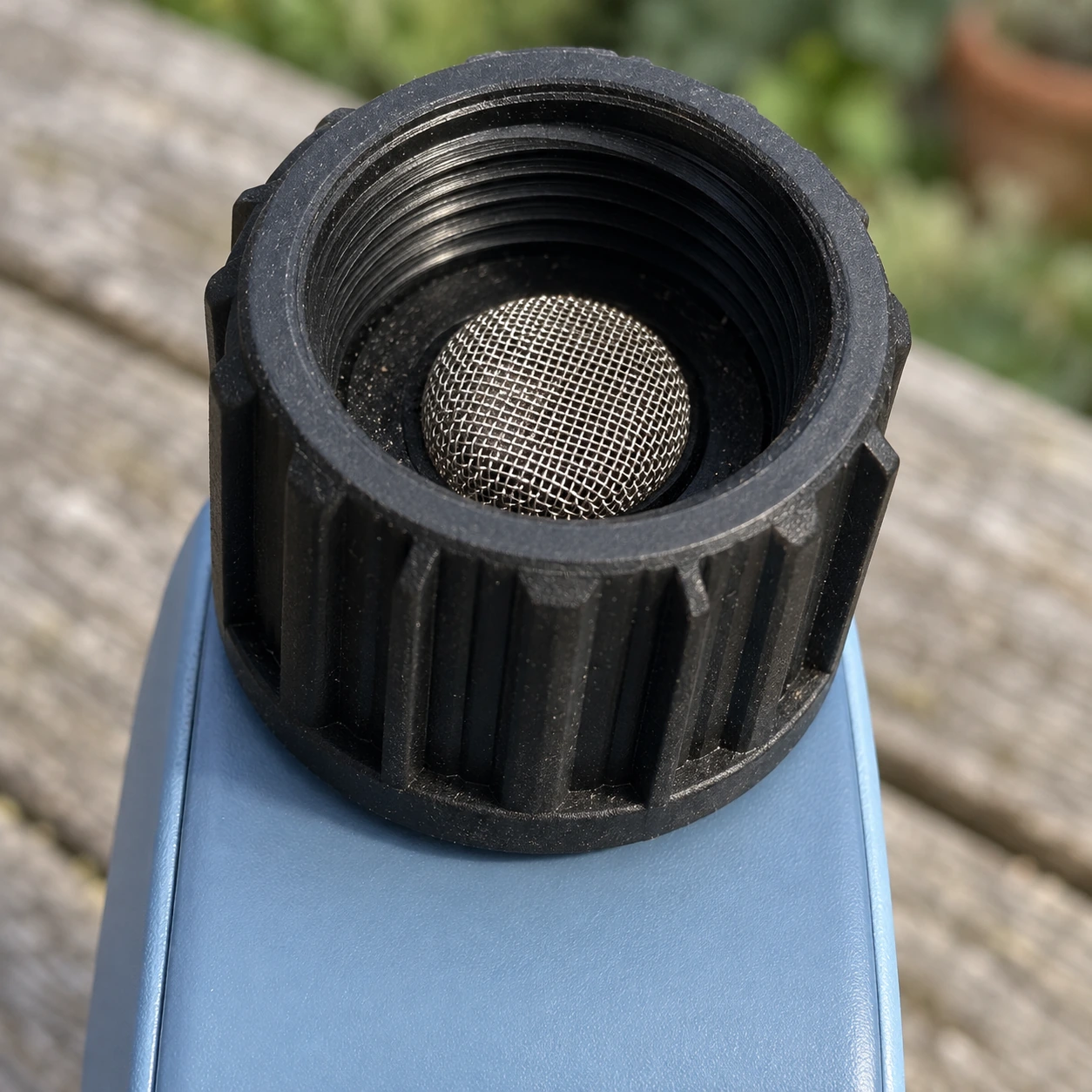 Vue rapprochée du col noir strié et de son filtre inox, prêt à se visser sur votre robinet