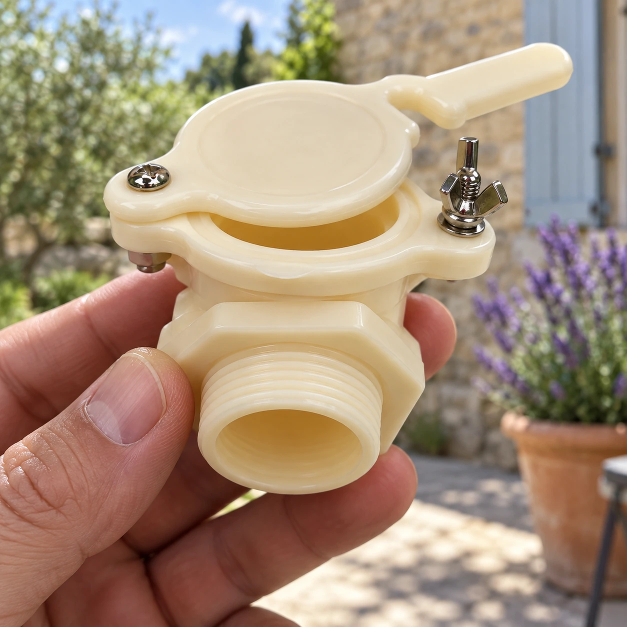 Embase hexagonale et tige filetée du robinet tenues en main, écrou et visserie métalliques