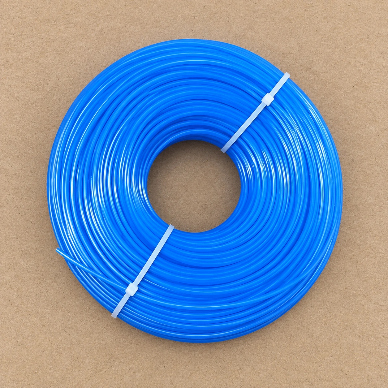 Contenu du colis vu de dessus : la bobine de fil bleu seule, tenue par ses colliers